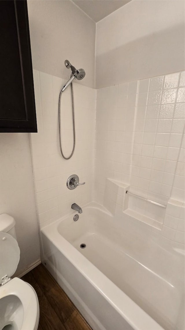 bathroom featuring toilet, bathtub / shower combination, and wood finished floors