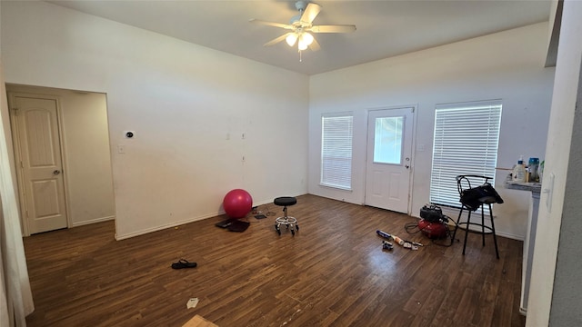 exercise room featuring a ceiling fan, wood finished floors, and baseboards