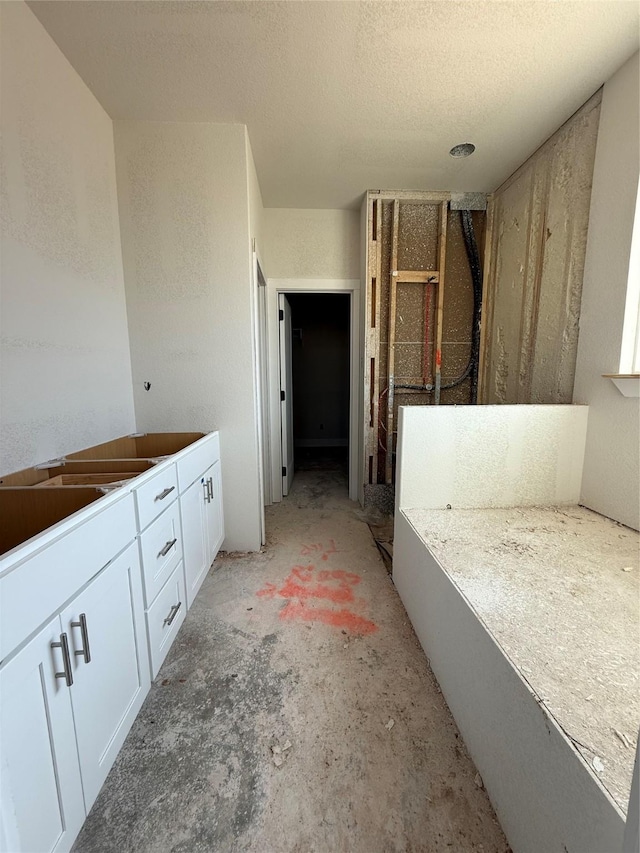 full bathroom featuring a stall shower, a textured ceiling, and unfinished concrete floors