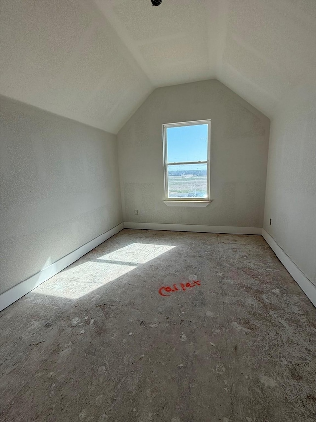 bonus room featuring baseboards, a textured ceiling, and lofted ceiling