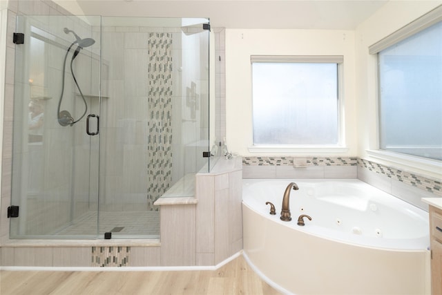 full bath featuring a shower stall, wood finished floors, and a whirlpool tub