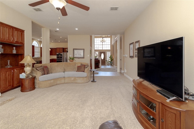 living area with recessed lighting, visible vents, light carpet, and ceiling fan with notable chandelier