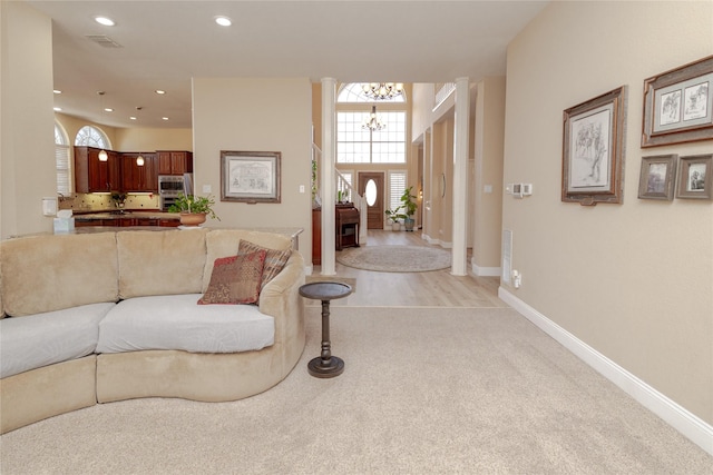 living room featuring a notable chandelier, recessed lighting, visible vents, and baseboards