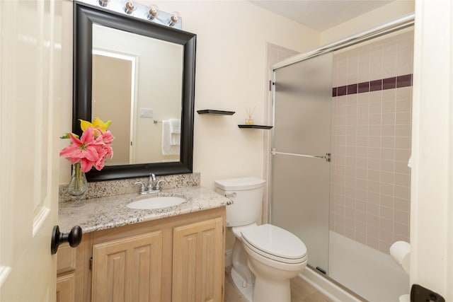 full bath featuring toilet, a stall shower, and vanity