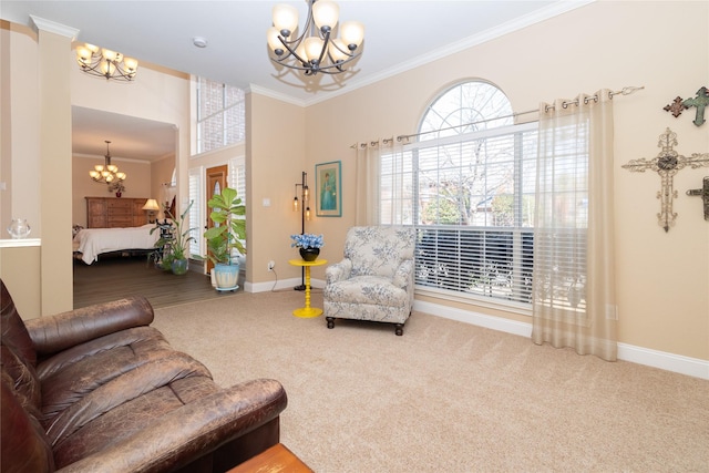 carpeted living area with a notable chandelier, baseboards, and ornamental molding