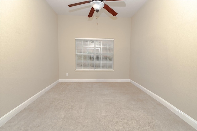 empty room featuring baseboards, light colored carpet, and ceiling fan