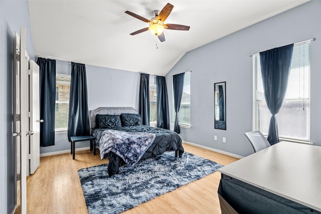 bedroom featuring baseboards, lofted ceiling, and light wood-style floors