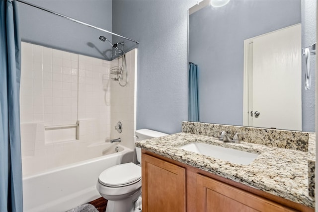 full bath with shower / bath combo with shower curtain, toilet, vanity, and a textured wall