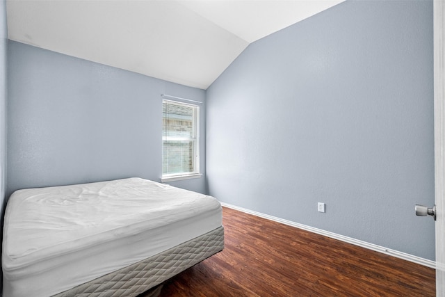 bedroom featuring vaulted ceiling, wood finished floors, and baseboards