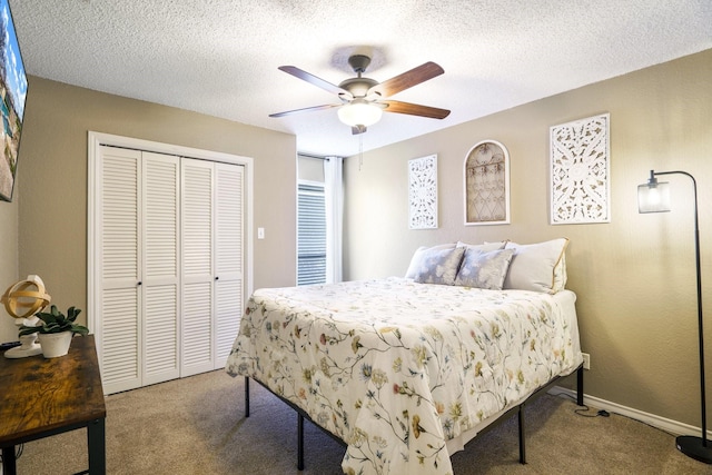 bedroom with a textured ceiling, a closet, carpet floors, baseboards, and ceiling fan