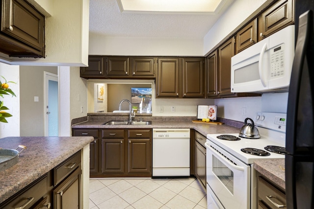 kitchen featuring a textured ceiling, white appliances, dark brown cabinetry, and a sink