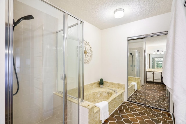 full bathroom with tile patterned flooring, a shower stall, vanity, a bath, and a textured ceiling