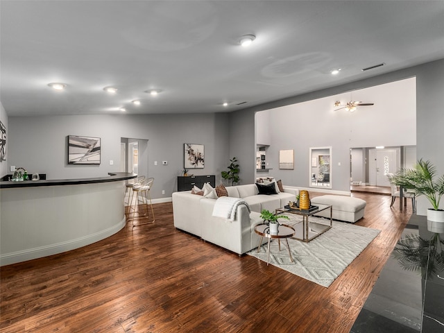 living area with visible vents, baseboards, lofted ceiling, recessed lighting, and wood finished floors