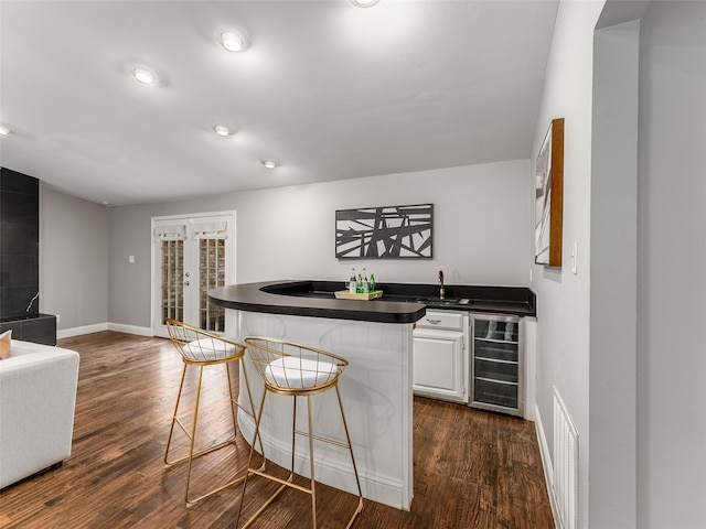 bar with visible vents, dark wood-type flooring, a sink, wine cooler, and indoor wet bar