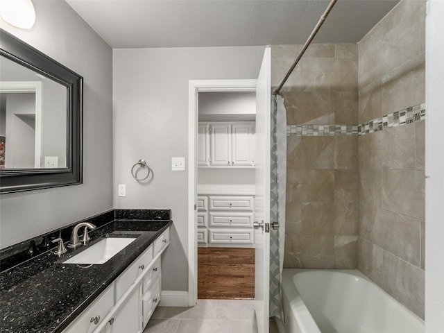 full bathroom with tile patterned floors, baseboards, shower / bath combo, and vanity