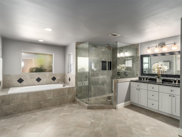 bathroom featuring visible vents, double vanity, a stall shower, a bath, and a sink