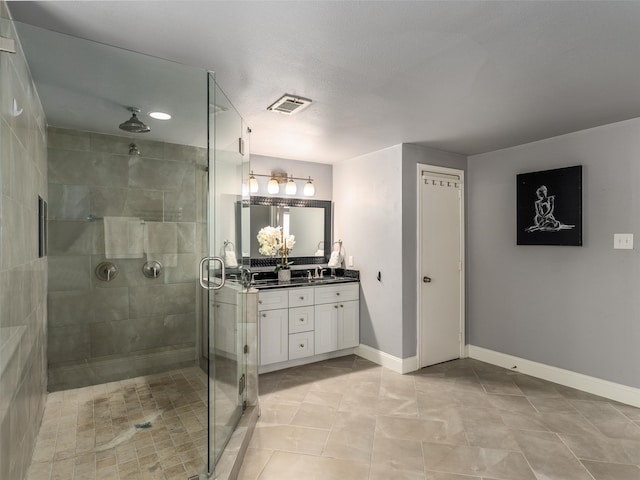 full bath featuring visible vents, a shower stall, vanity, and baseboards