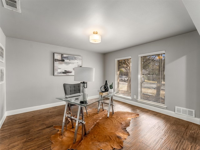 office area featuring visible vents, baseboards, and wood finished floors