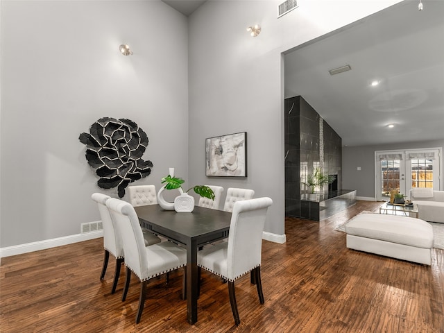 dining space with wood finished floors, visible vents, and baseboards