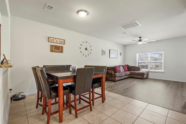 dining space featuring light tile patterned floors, visible vents, and a ceiling fan