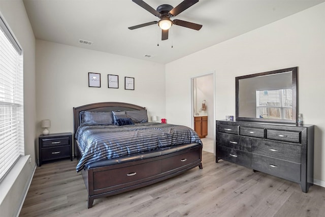 bedroom featuring visible vents, light wood-style flooring, connected bathroom, and ceiling fan