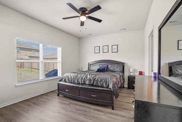 bedroom featuring light wood-type flooring, visible vents, and baseboards