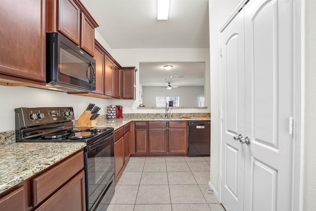 kitchen with light stone countertops, visible vents, light tile patterned flooring, a sink, and black appliances