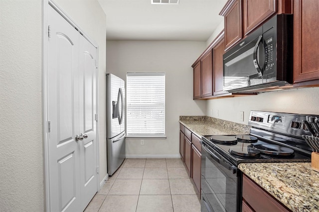 kitchen featuring visible vents, baseboards, light stone countertops, light tile patterned floors, and black appliances