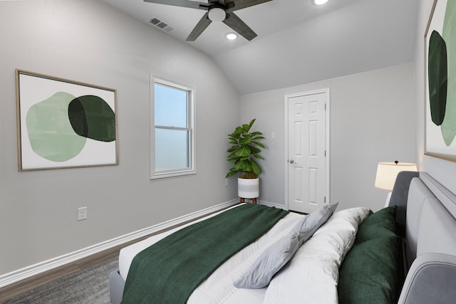 bedroom with visible vents, baseboards, wood finished floors, and vaulted ceiling