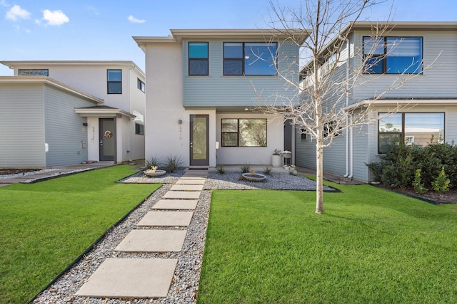 view of front of house with stucco siding and a front yard