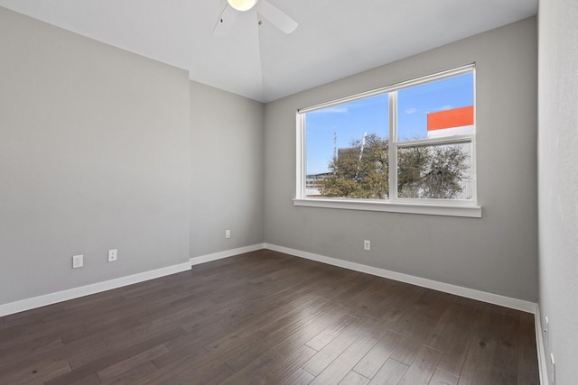 empty room with baseboards, ceiling fan, dark wood-style flooring, and vaulted ceiling