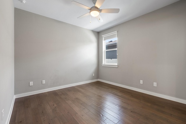 spare room featuring dark wood finished floors, baseboards, and ceiling fan