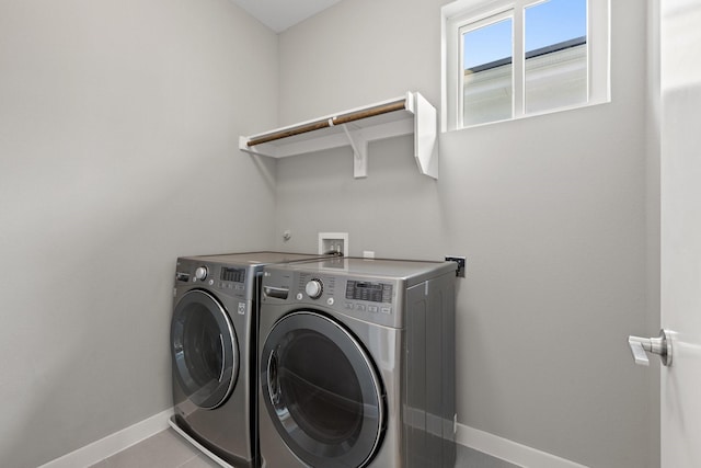 laundry area with tile patterned floors, baseboards, washing machine and dryer, and laundry area