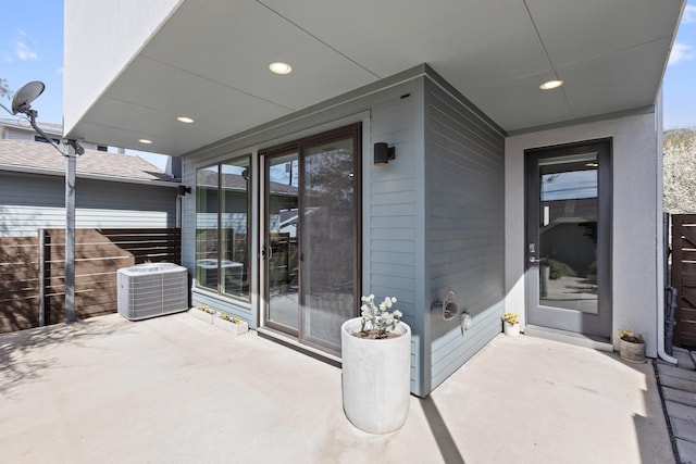 entrance to property featuring central air condition unit and a patio