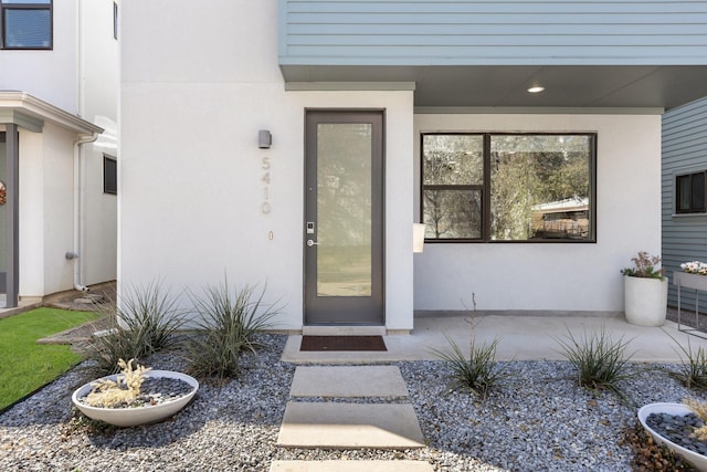 property entrance with stucco siding