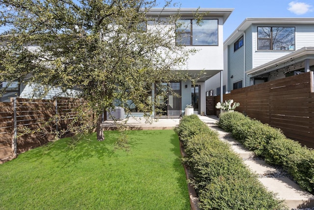 back of property featuring a patio area, a lawn, central AC unit, and fence