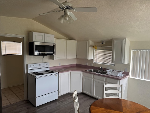 kitchen with stainless steel microwave, a textured ceiling, electric stove, and a sink