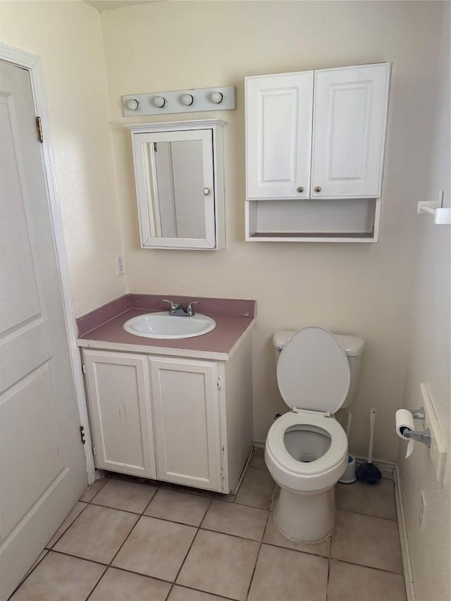 bathroom featuring tile patterned flooring, toilet, vanity, and baseboards