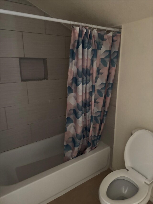 full bathroom featuring toilet and shower / tub combo with curtain