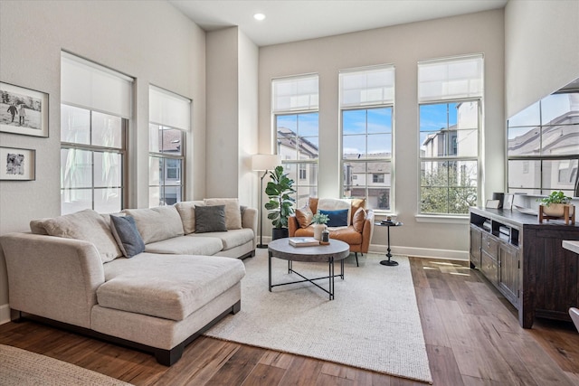 living room featuring recessed lighting, dark wood-style floors, and baseboards