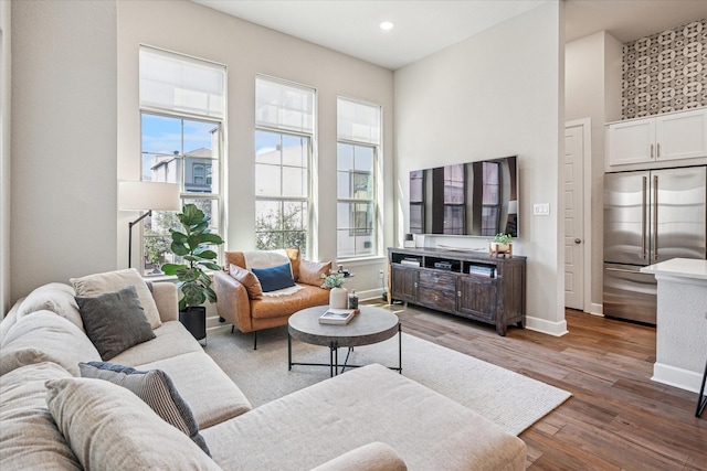 living area with recessed lighting, baseboards, and wood finished floors