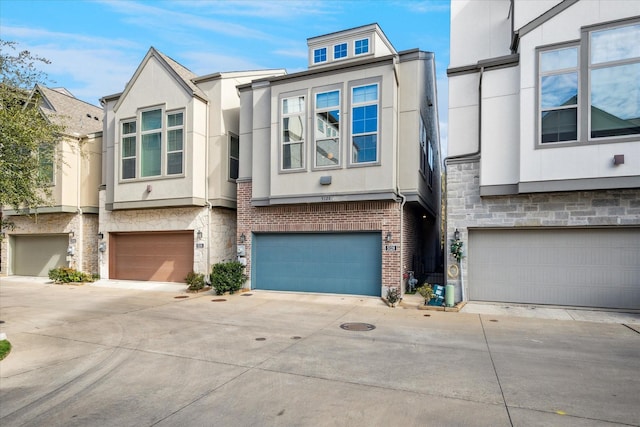 view of property with stone siding, stucco siding, concrete driveway, and a garage