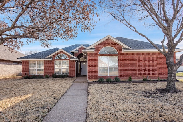 ranch-style house featuring brick siding and a shingled roof