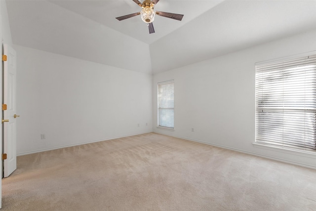 spare room with light carpet, a ceiling fan, and vaulted ceiling