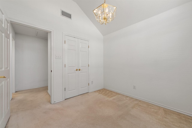 unfurnished bedroom featuring visible vents, high vaulted ceiling, an inviting chandelier, light colored carpet, and attic access