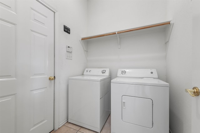 laundry area featuring washing machine and clothes dryer, laundry area, and light tile patterned flooring