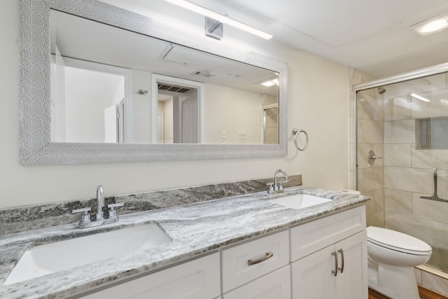 bathroom featuring a sink, toilet, a stall shower, and double vanity