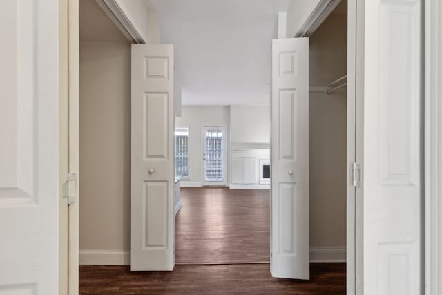 hallway with baseboards and dark wood-style flooring