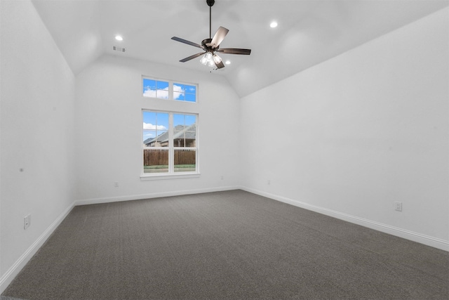 empty room with dark colored carpet, baseboards, ceiling fan, and vaulted ceiling