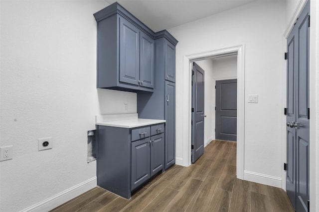 laundry room with baseboards, cabinet space, dark wood-style flooring, and electric dryer hookup